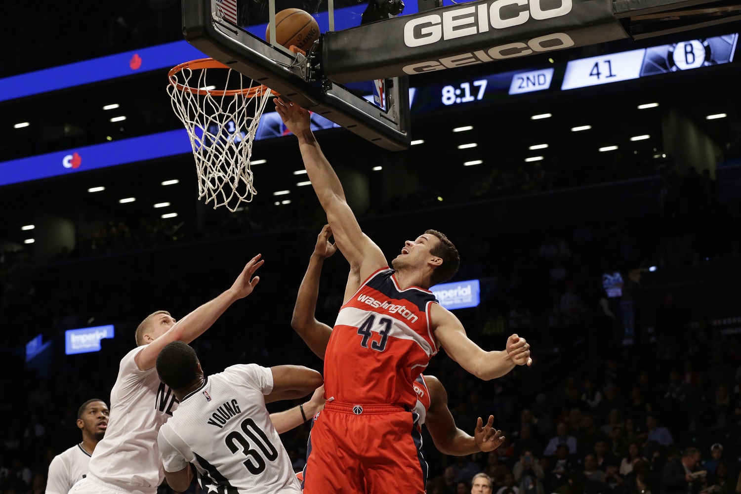 Washington Wizards forward Kris Humphries (43) goes to the basket past Brooklyn Nets forward Thaddeus Young (30) and center Mason Plumlee during the first half of an NBA basketball game, Friday, April 10, 2015, at  New York.  (AP Photo/Mary Altaffer)