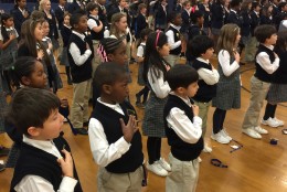 Students at St. John's Episcopal School in Olney, Maryland pray and say the pledge of allegiance before the ceremony of appreciation that included Montgomery County Police officers and the father of fallen officer Noah Leotta. (WTOP/Kristi King)