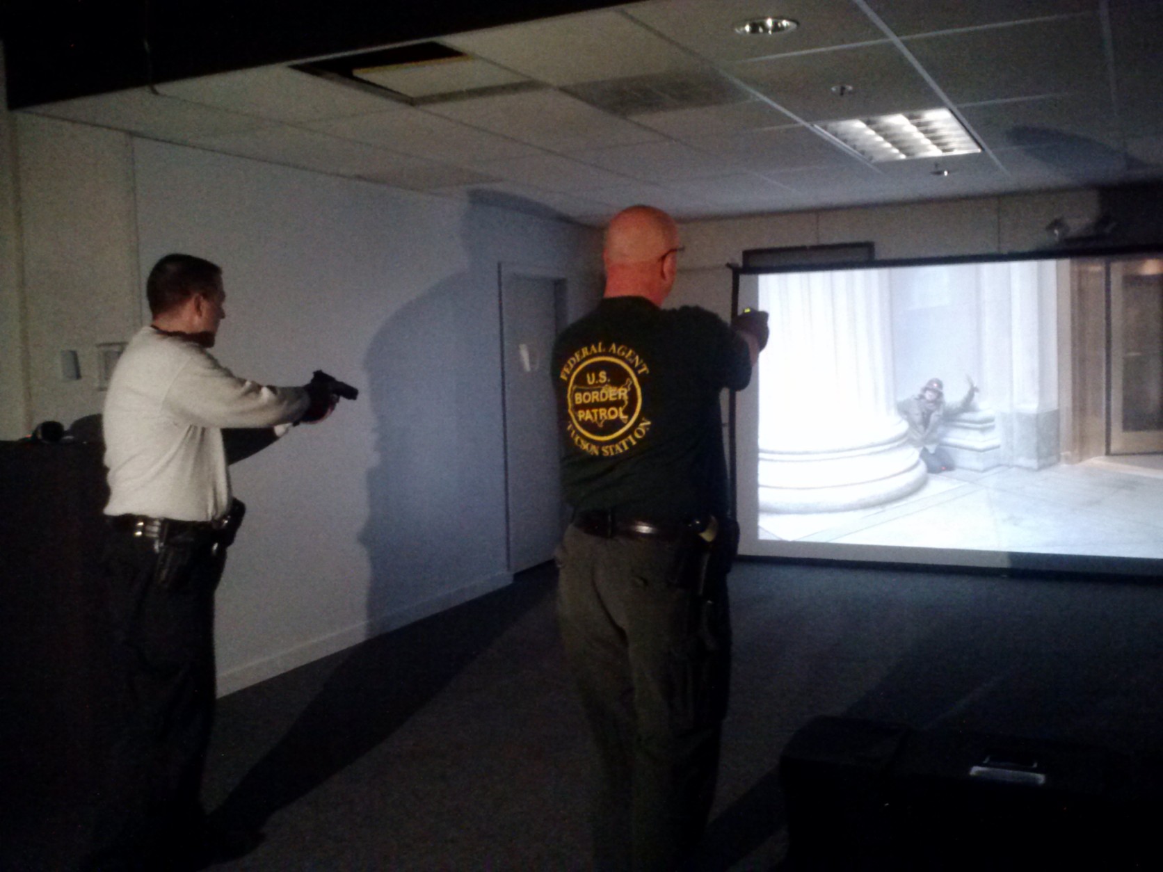 Officers point simulated weapons at the target shown on screen during a de-escalation simulation. (WTOP/Max Smith)