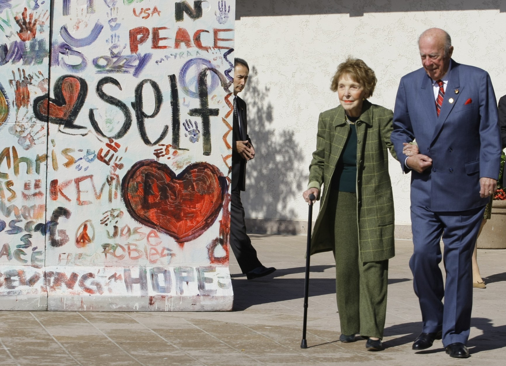 Former First Lady Nancy Reagan, left, is helped by George Shultz, Secretary of State under President Reagan, as they arrive at The Ronald Reagan Presidential Library in Simi Valley, Calif. on Friday, November 6, 2009. The Ronald Reagan Presidential Foundation and Library and The Heritage Foundation commemorate the 20th anniversary of the fall of the Berlin Wall and the advent of freedom and democracy in Eastern Europe. (AP Photo/Damian Dovarganes)