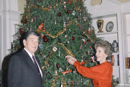 President Ronald Reagan and first lady Nancy Reagan pose next to their Christmas tree, at the White House , Dec. 22, 1988. (AP Photo/Barry Thumma)