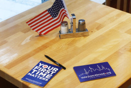 Post cards and a US flag are placed on a table at a polling station for Democrats abroad in a restaurant in Frankfurt, Germany, Tuesday, March 1, 2016. The United States have their presidential primary elections on so-called Super Tuesday. (AP Photo/Michael Probst)