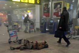 In this photo provided by Georgian Public Broadcaster and photographed by Ketevan Kardava, an injured man lies on the floor in Brussels Airport in Brussels, Belgium, after explosions were heard Tuesday, March 22, 2016. A developing situation left a number dead in explosions that ripped through the departure hall at Brussels airport Tuesday, police said. All flights were canceled, arriving planes were being diverted and Belgium's terror alert level was raised to maximum, officials said. (Ketevan Kardava/ Georgian Public Broadcaster via AP)