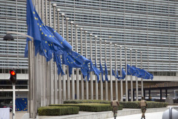 Two soldiers from the Belgian Army patrol outside EU headquarters as EU flags fly at half mast after an explosion in Brussels on Tuesday, March 22, 2016. Explosions, at least one likely caused by a suicide bomber, rocked the Brussels airport and subway system Tuesday, prompting a lockdown of the Belgian capital and heightened security across Europe. At least 26 people were reported dead. (AP Photo/Virginia Mayo)