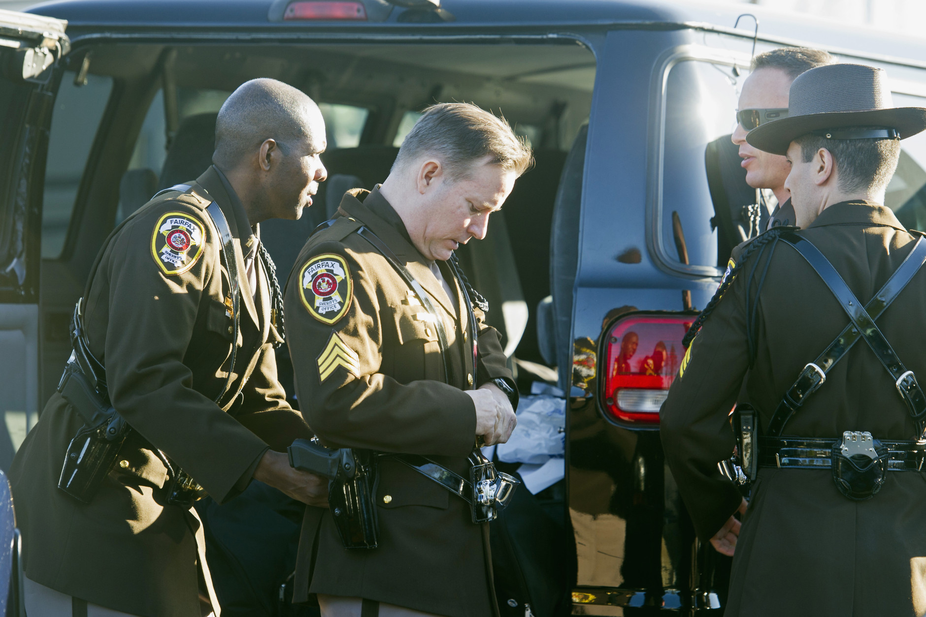 Members of the Fairfax County, Va. Sheriff's Department assist each other in dressing for the funeral of Prince William County, Va. Police Officer Ashley Guindon, Tuesday, March 1, 2016, at the Hylton Memorial Chapel in Woodbrige, Va. Guindon was shot and killed, on her first day of work for Prince William County, when she responded to a domestic dispute in Woodbridge on Saturday. Feb. 27, 2016.  (AP Photo/Cliff Owen)