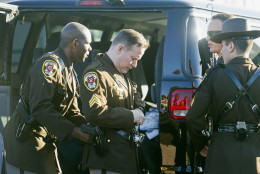 Members of the Fairfax County, Va. Sheriff's Department assist each other in dressing for the funeral of Prince William County, Va. Police Officer Ashley Guindon, Tuesday, March 1, 2016, at the Hylton Memorial Chapel in Woodbrige, Va. Guindon was shot and killed, on her first day of work for Prince William County, when she responded to a domestic dispute in Woodbridge on Saturday. Feb. 27, 2016.  (AP Photo/Cliff Owen)