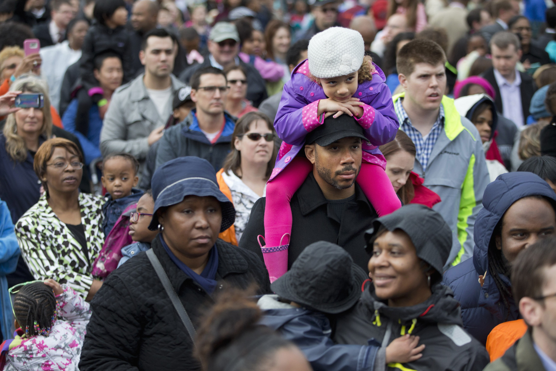 A child sits on a man's shoulders as they wait for the arrival of President Barack Obama for the White House Easter Egg Roll on the South Lawn of the White House in Washington, Monday, March 28, 2016. Thousands of children gathered at the White House for the annual Easter Egg Roll. This year's event features  live music, sports courts, cooking stations, storytelling, and Easter egg rolling. (AP Photo/Jacquelyn Martin)