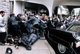 In this March 30, 1981 file photo released by the White House, White House press secretary James Brady, face down at right, and Washington, D.C., police officer Thomas Delahanty, front, lie on the ground after being wounded during the assassination attempt on President Reagan as he was leaving the Washington Hilton, March 30, 1981. (AP Photo/White House, Michael Evans)