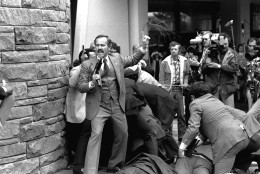 An unidentified secret agent, automatic weapon drawn, yells orders after shots were fired at President Ronald Reagan Monday, March 30, 1981, outside a Washington hotel. (AP Photo/Ron Edmonds)