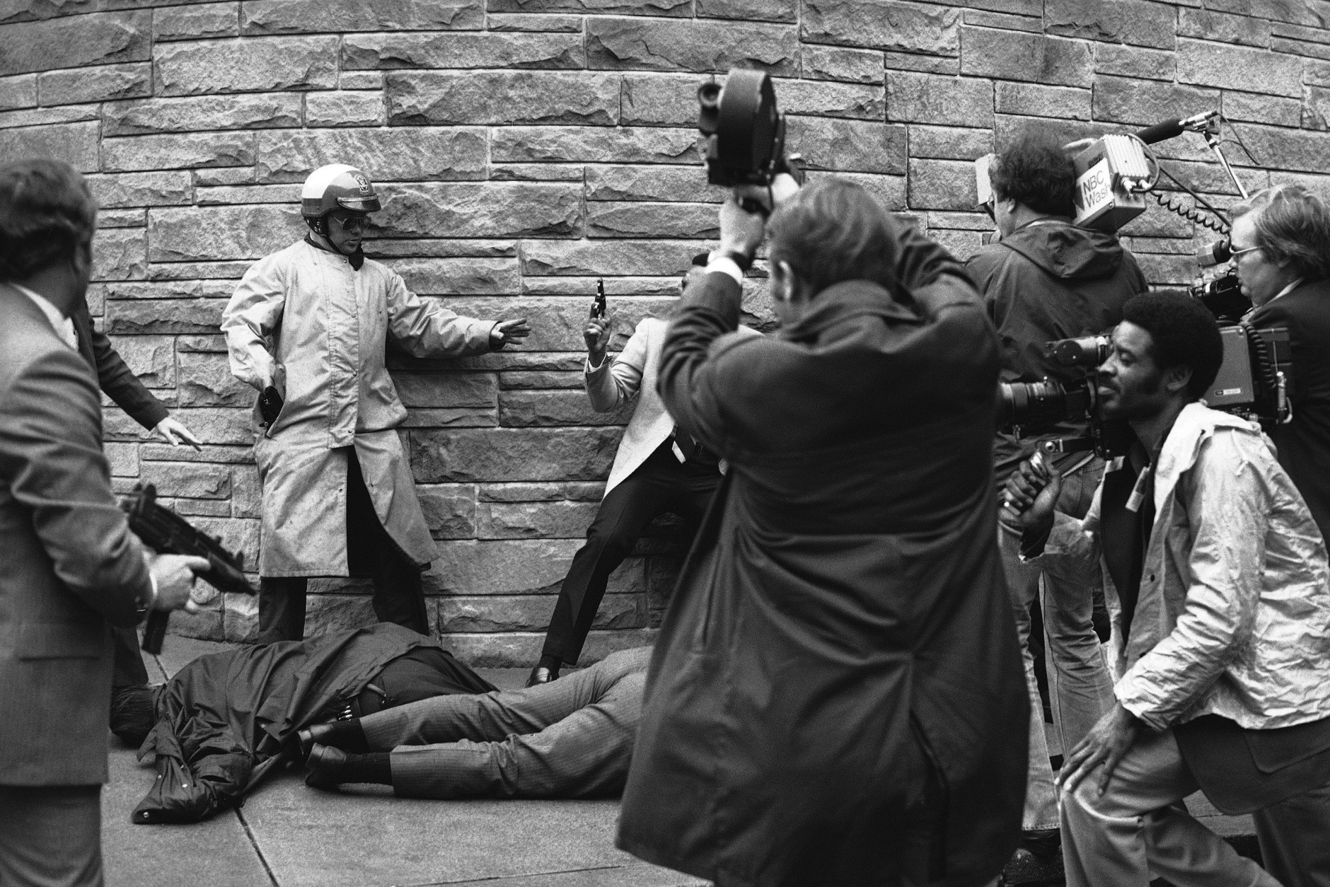 White House press secretary James Brady lies wounded on the sidewalk outside a Washington hotel after being shot during an assassination attempt on U.S. President Ronald Reagan on Monday, March 30, 1981. In the background secret service agents and police wrestle the alleged assailant to the ground. (AP Photo/Ron Edmonds)