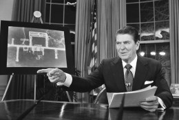 President Reagan points as he addresses the nation on television March 23, 1983, from Washington in support of his proposed defense budget.  At left is a picture of Soviet Migs in western Cuba according to the White House.  The House voted earlier to cut the defense budget in favor of social programs.  (AP Photo/Dennis Cook)