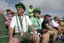 Ed Lohmeyer, left, and Patty Hogan, of Cream Ridge, N.J., don green attire in honor of St. Patrick's Day while watching from the stands at the 18th green during the first round of the Arnold Palmer Invitational golf tournament in Orlando, Fla., Thursday, March 17, 2016. (AP Photo/Phelan M. Ebenhack)
