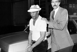 An unidentified Los Angeles Police homicide detective leads handcuffed Marvin Gay Sr. into LAPD central headquarters at Parker Center, Los Angeles, Calif., on April 1, 1984. Gay Sr. was taken into custody in connection with the shooting death of his son, singer Marvin Gaye Jr., which occured while Gaye Jr. was visiting his parents' home. (AP Photo/Lennox McLendon)