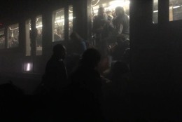 In this photo provided by Evan Lamos passengers clamber from a metro carriage after explosions in Brussels Tuesday, March 22, 2016. Authorities locked down the Belgian capital on Tuesday after explosions rocked the Brussels airport and subway system, killing  a number of people and injuring many more. Belgium raised its terror alert to its highest level, diverting arriving planes and trains and ordering people to stay where they were. Airports across Europe tightened security.  (Evan Lamos via AP)