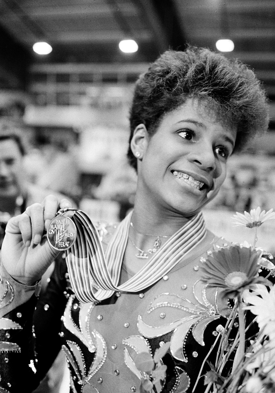 Debi Thomas of the United States shows off the gold medal she won at the World Figure Skating Championship in Geneva, Switzerland, on March 21, 1986. Thomas, the first ever black woman to win this title, defeated  defending East German champion Katarina Witt. (AP Photo)