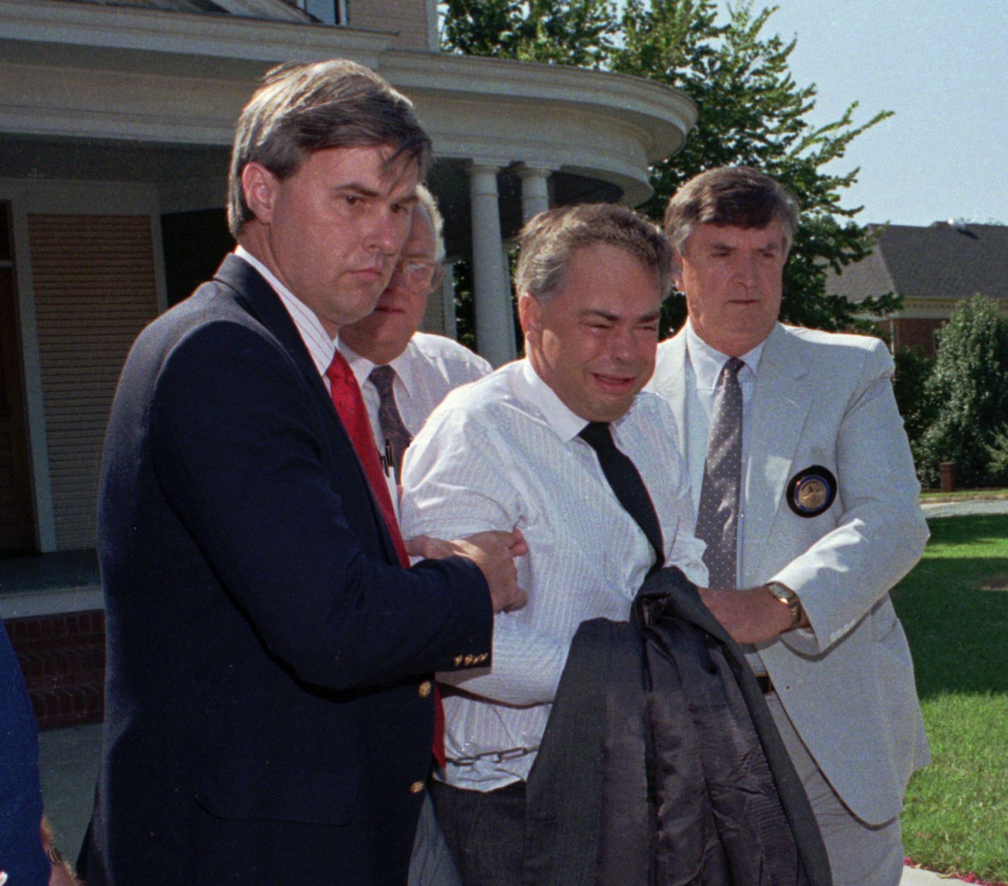 U.S. marshals escort former PTL leader Jim Bakker, center, from his attorney's office to a waiting car Thursday afternoon Aug. 31, 1989 in Charlotte, N.C.   Bakker, who did not appear in court Thursday, was taken under order to the State Correctional Institute at Butner, N.C., for psychiatric evaluation.  (AP Photo/Chuck Burton)