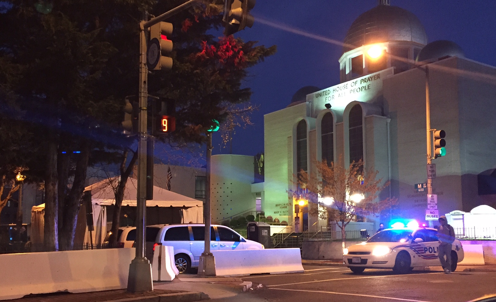 Crews work to close roads across D.C. in the early morning hours before the Nuclear Security Summit. Police block the road in front of the United House of Prayer while barriers are put in place. (WTOP/ Dennis Foley)