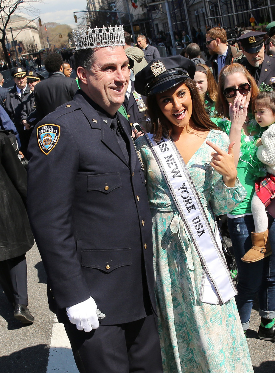 A police officer poses with Miss New York at the 255th annual St. Patricks Day Parade along Fifth Avenue in New York City on March 17, 2016 in New York City. (Photo by Jemal Countess/Getty Images)