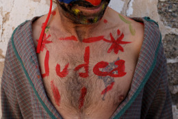 An actor representing a 'Judio' shows his bodypainting reading 'Judea' before taking part in 'La Judea' during a Holy Friday procession on March 25, 2016 in Cuevas del Almanzora, in Almeria province, Spain. 'La Judea' belongs to 'Hermandad de Nuestro Padre Jesus Nazareno'. Certain families of Cuevas del Almanzora have kept this tradition alive for more than a hundred years. Men wearing costume hold a wood maze representing 'los Judios' (the Jewish) pretend to beat and pull 'El Senor' who represents Jesus Christ around the village as he holds a cross on his back. Spain celebrates holy week before Easter with processions in most Spanish towns and villages. (Photo by Pablo Blazquez Dominguez/Getty Images)