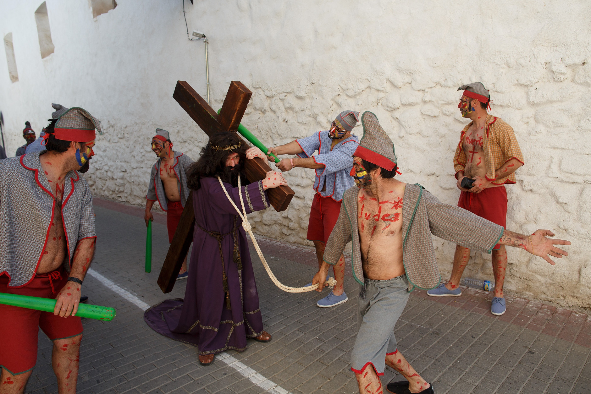 CUEVAS DEL ALMANZORA, SPAIN - MARCH 25:  Actors representing the 'Judios' and Jesus Christ take part in 'La Judea' along the streets during a Holy Friday procession on March 25, 2016 in Cuevas del Almanzora, in Almeria province, Spain. 'La Judea' belongs to 'Hermandad de Nuestro Padre Jesus Nazareno'. Certain families of Cuevas del Almanzora have kept this tradition alive for more than a hundred years. Men wearing costume hold a wood maze representing 'los Judios' (the Jewish) pretend to beat and pull  'El Senor' who represents Jesus Christ around the village as he holds a cross on his back. Spain celebrates holy week before Easter with processions in most Spanish towns and villages.  (Photo by Pablo Blazquez Dominguez/Getty Images)