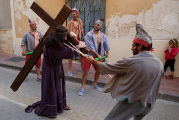 Actors representing the 'Judios' and Jesus Christ take part in 'La Judea' along the streets during a Holy Friday procession on March 25, 2016 in Cuevas del Almanzora, in Almeria province, Spain. Certain families of Cuevas del Almanzora have kept this tradition alive for more than a hundred years. Men wearing costume hold a wood maze representing 'los Judios' (the Jewish) pretend to beat and pull 'El Senor' who represents Jesus Christ around the village as he holds a cross on his back. Spain celebrates holy week before Easter with processions in most Spanish towns and villages. (Photo by Pablo Blazquez Dominguez/Getty Images)