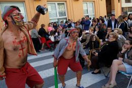 Members of the public watch men acting during 'La Judea' along the streets during a Holy Friday procession on March 25, 2016 in Cuevas del Almanzora, in Almeria province, Spain. 'La Judea' belongs to 'Hermandad de Nuestro Padre Jesus Nazareno'. Certain families of Cuevas del Almanzora have kept this tradition alive for more than a hundred years. Men wearing costume hold a wood maze representing 'los Judios' (the Jewish) pretend to beat and pull 'El Senor' who represents Jesus Christ around the village as he holds a cross on his back. Spain celebrates holy week before Easter with processions in most Spanish towns and villages. (Photo by Pablo Blazquez Dominguez/Getty Images)