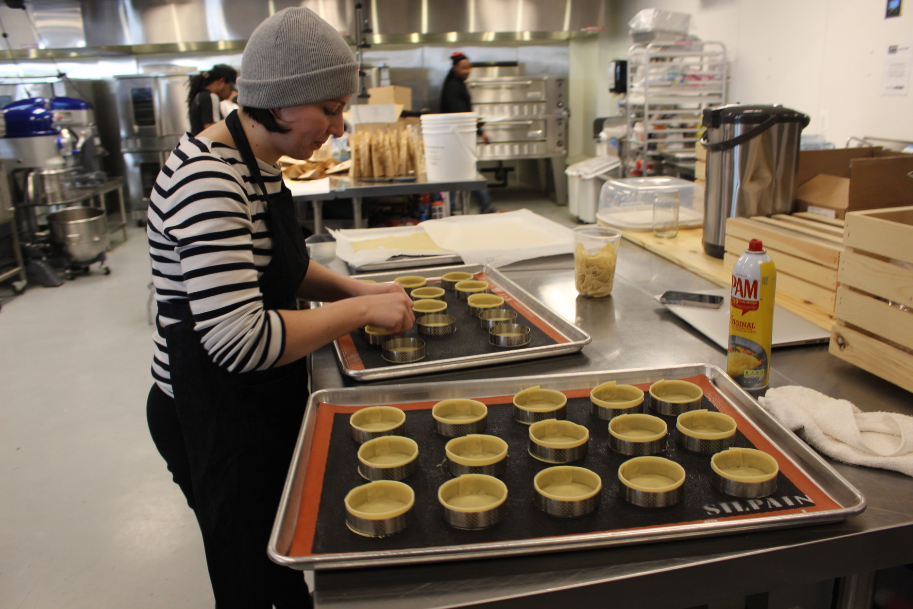 A Union Kitchen member prepares tiny pastry tins in the communal kitchen. (WTOP/Dana Gooley) 