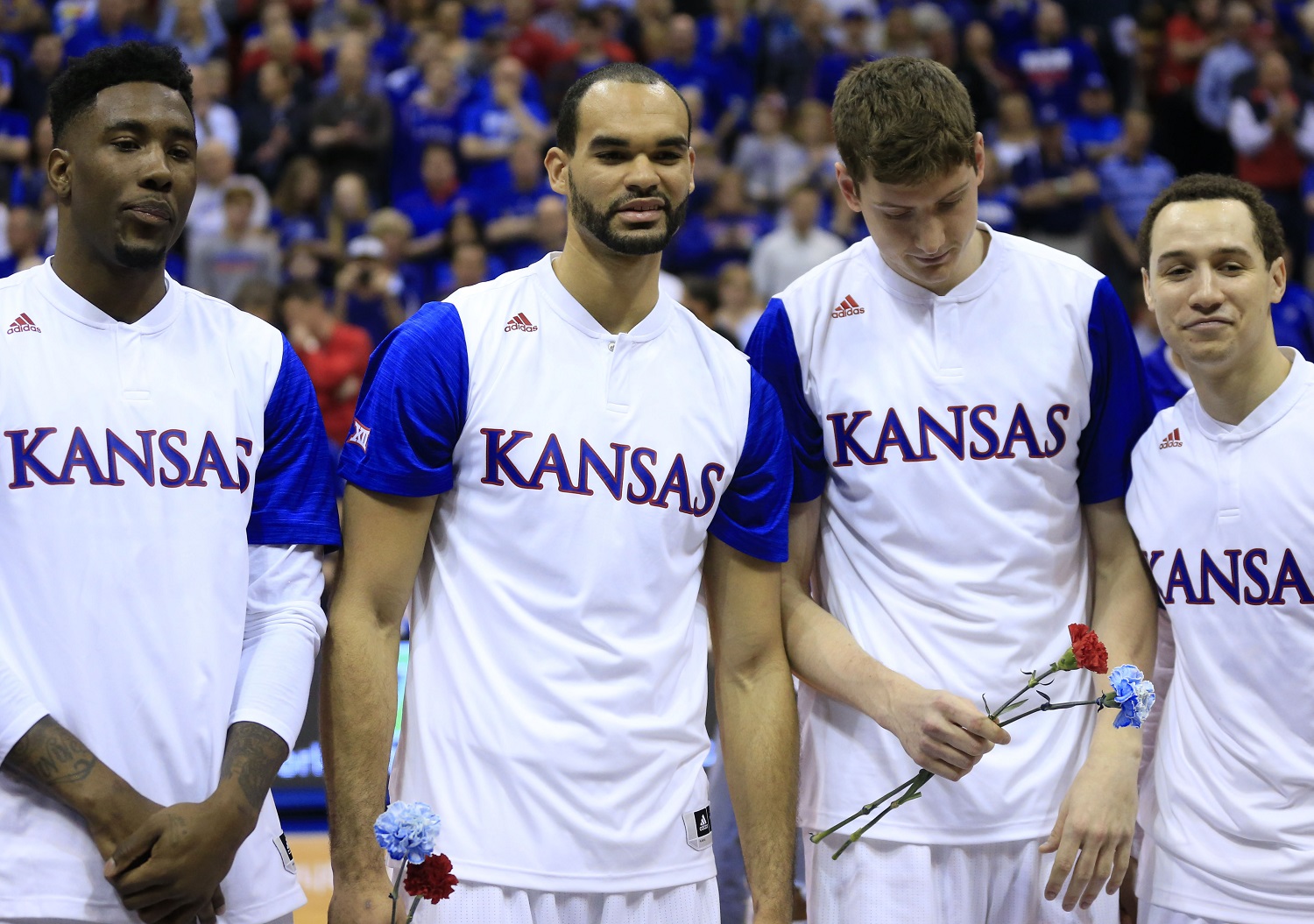 Kansas seniors, from left, Jamari Traylor, Perry Ellis, Hunter Mickelson and Evan Manning, right, pose for a photograph before an NCAA college basketball game against Iowa State in Lawrence, Kan., Saturday, March 5, 2016. (AP Photo/Orlin Wagner)