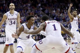 Kansas players celebrate after winning an NCAA college basketball game against West Virginia in the finals of the Big 12 conference tournament Saturday, March 12, 2016, in Kansas City, Mo. (AP Photo/Charlie Riedel)