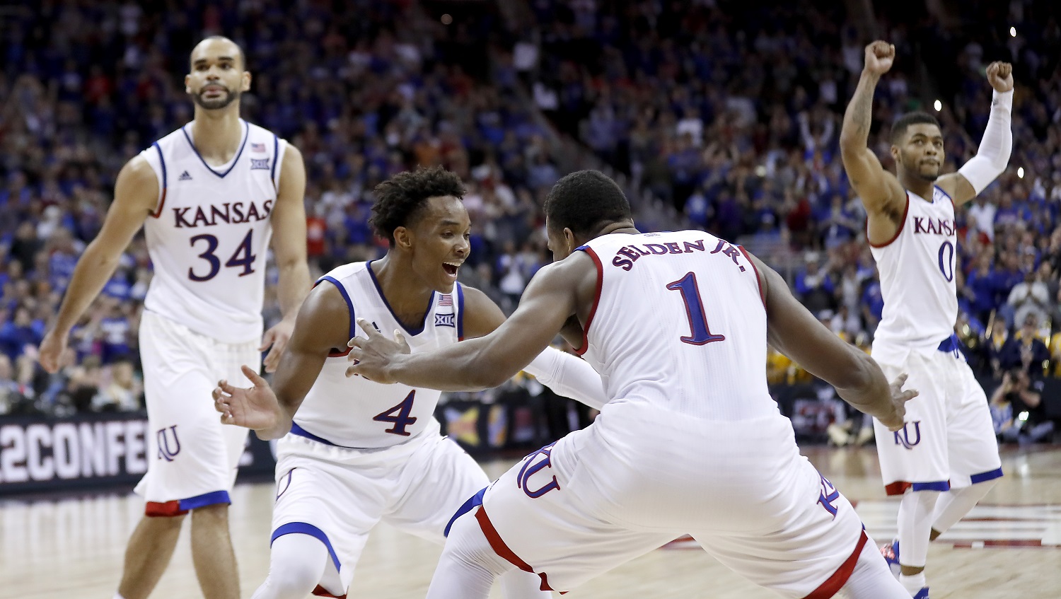 Kansas players celebrate after winning an NCAA college basketball game against West Virginia in the finals of the Big 12 conference tournament Saturday, March 12, 2016, in Kansas City, Mo. (AP Photo/Charlie Riedel)