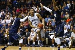WEST LONG BRANCH, NJ - JANUARY 9: Micah Seaborn #10 of the Monmouth Hawks attempts a shot between Ayron Hutton #5 and Daniel Harris #23 of the Quinnipiac Bobcats during the second half of a college basketball game at the MAC on January 9, 2016 in West Long Branch, New Jersey. Monmouth won 88-74. (Photo by Rich Schultz /Getty Images)