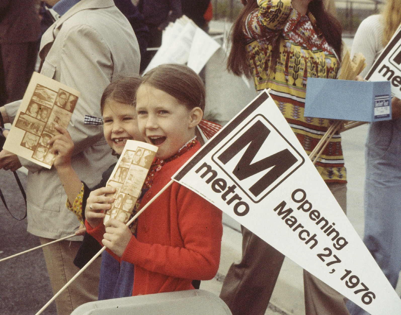Two young girls excitedly stand among the crowd on the opening day of the Rhode Island Avenue Metro station on  March 27, 1976. 
(WMATA/Paul Myatt)
