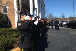 As bagpipes play, officers salute Officer Ashley Guindon. (WTOP/Jamie Forzato)