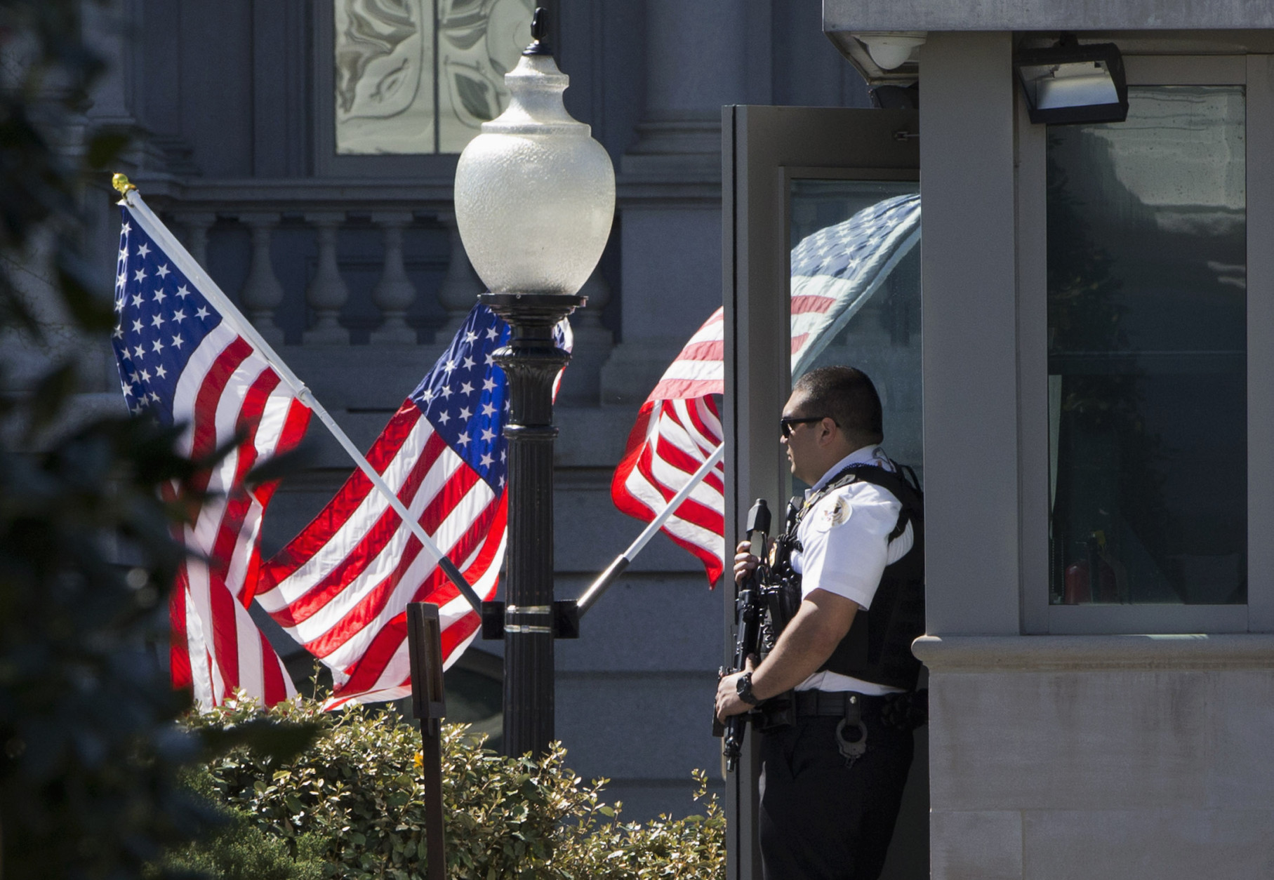 A Secret Service Uniformed Division Officer holds his weapon by a guard booth by the West Wing of the White House in Washington, Monday, March 28, 2016, after reports of an active shooter at the U.S. Capitol. (AP Photo/Jacquelyn Martin)