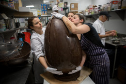Photo of Jennifer Costa joining two halves of a giant chocolate Easter egg