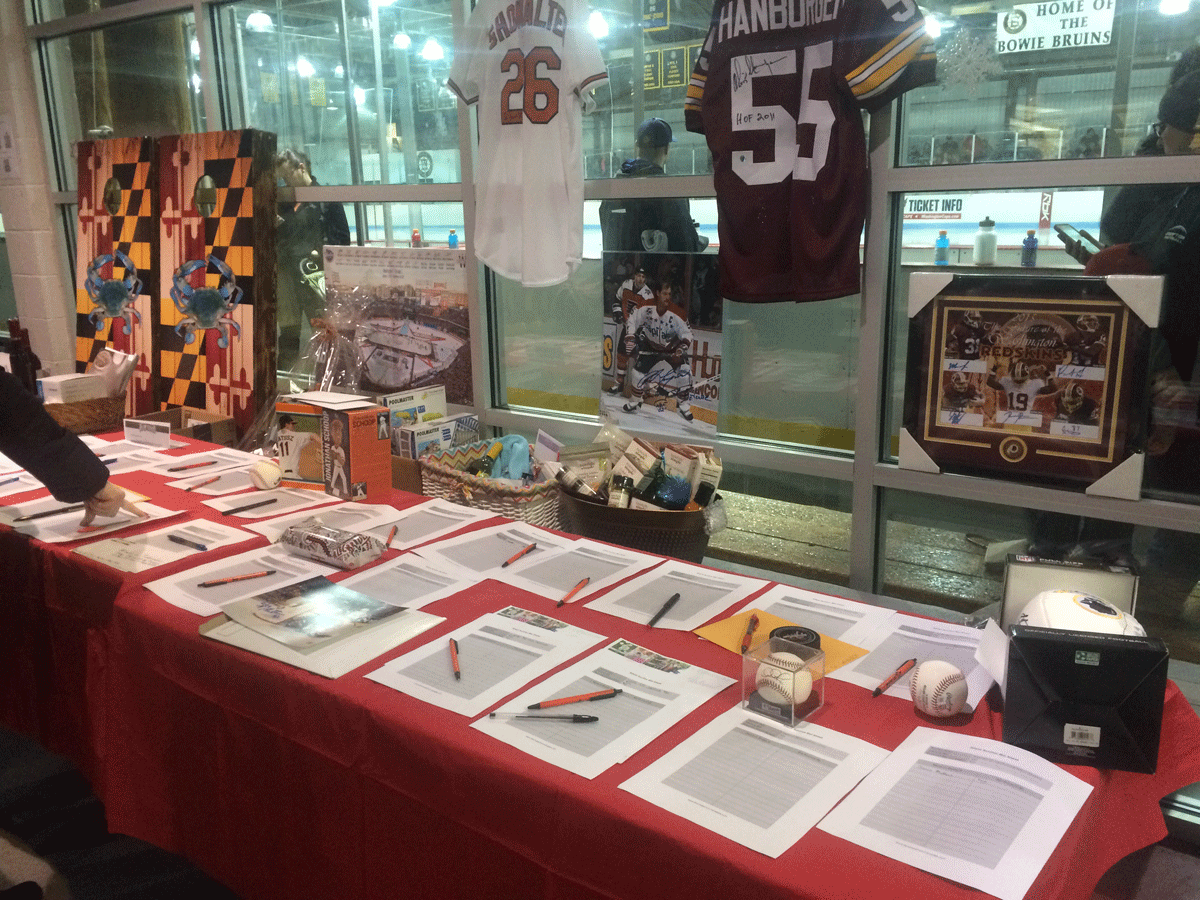 Silent auction at Saturday's Guns and Hoses benefit. (WTOP/Meg Hasken)