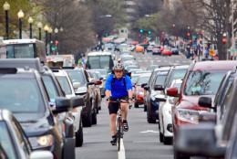 A cyclist commutes to work on 15th Street NW as traffic backs up from Capitol Hill to Fort Totten during Metro's shutdown. (WTOP/Dave Dildine)