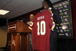 Washington Redskins first round NFL football draft pick, Robert Griffin III, poses with a Redskins jersey at a press conference, Saturday, April 28, 2012, in Landover, Md. (AP Photo/Nick Wass)