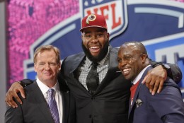 Virginia tackle Morgan Moses poses for photos with NFL commissioner Roger Goodell and former Washington Redskins' linebacker London Fletcher after being selected as the 66th pick during the third  round of the 2014 NFL Draft, Friday, May 9, 2014, in New York. (AP Photo/Jason DeCrow)