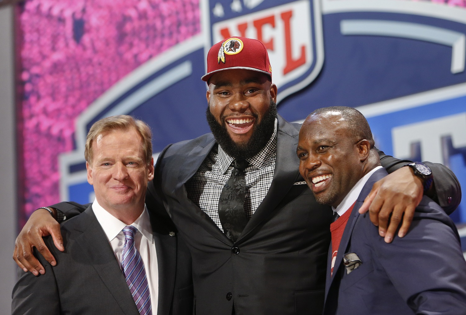 Virginia tackle Morgan Moses poses for photos with NFL commissioner Roger Goodell and former Washington Redskins' linebacker London Fletcher after being selected as the 66th pick during the third  round of the 2014 NFL Draft, Friday, May 9, 2014, in New York. (AP Photo/Jason DeCrow)