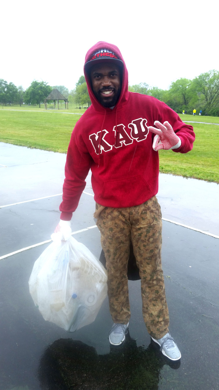 Volunteer William Blake, who's a member of Kappa Alpha Psi's D.C. alumni chapter, poses with his plastic bag during an Earth Day cleanup at Anacostia's River Terrace Park. (WTOP/Allison Keyes)