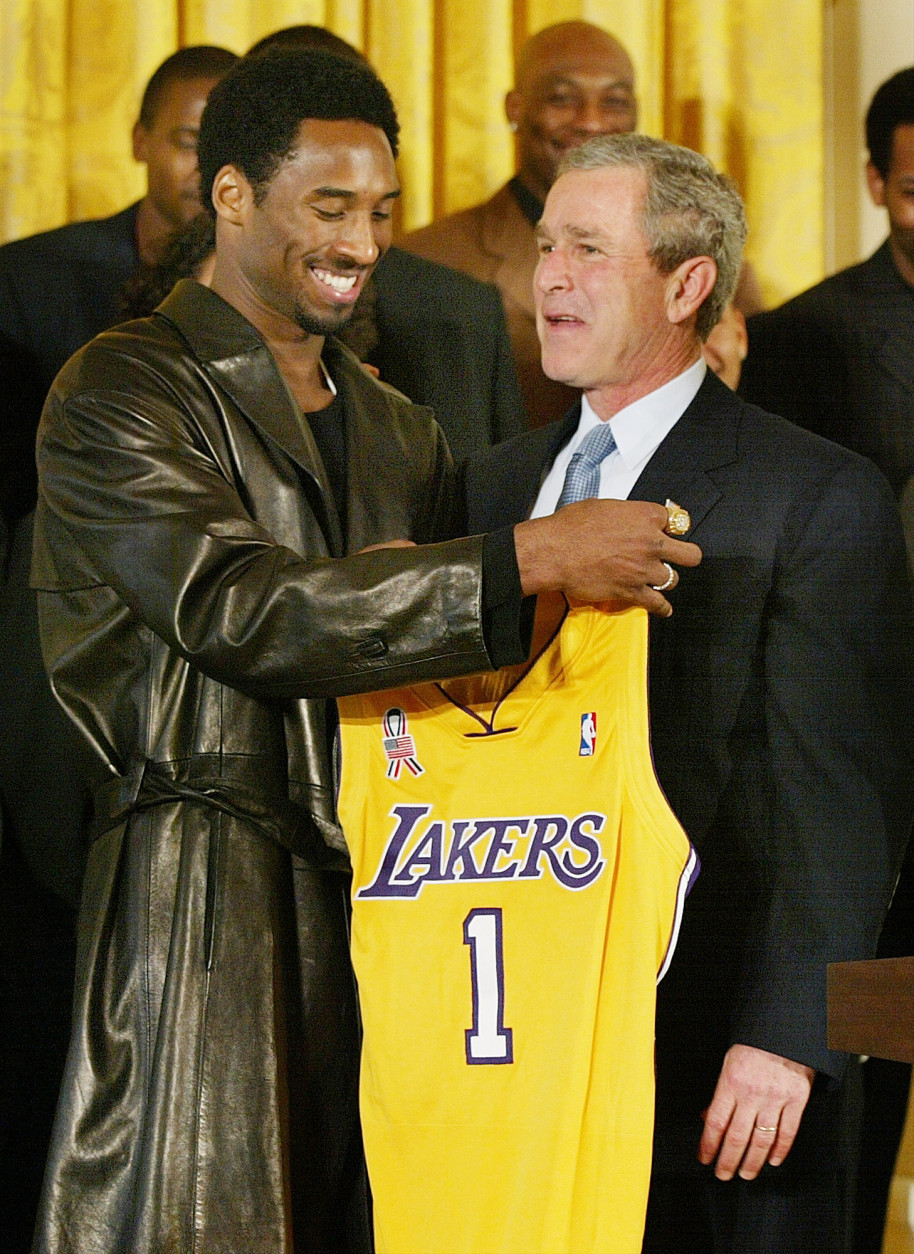 Los Angeles Lakers guard Kobe Bryant holds up a team jersey to the chest of President Bush during a ceremony for the 2001 NBA World Champions in the East Room of the White House, Monday, Jan. 28, 2002. (AP Photo/Doug Mills)