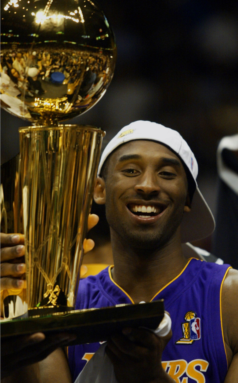 Los Angeles Lakers guard Kobe Bryant holds up the NBA Championship trophy after the Lakers defeated the New Jersey Nets 113-107 in Game 4 of the NBA Finals, Wednesday, June 12, 2002, in East Rutherford, N.J.  The Lakers won their third consecutive NBA championship. (AP Photo/Rusty Kennedy)