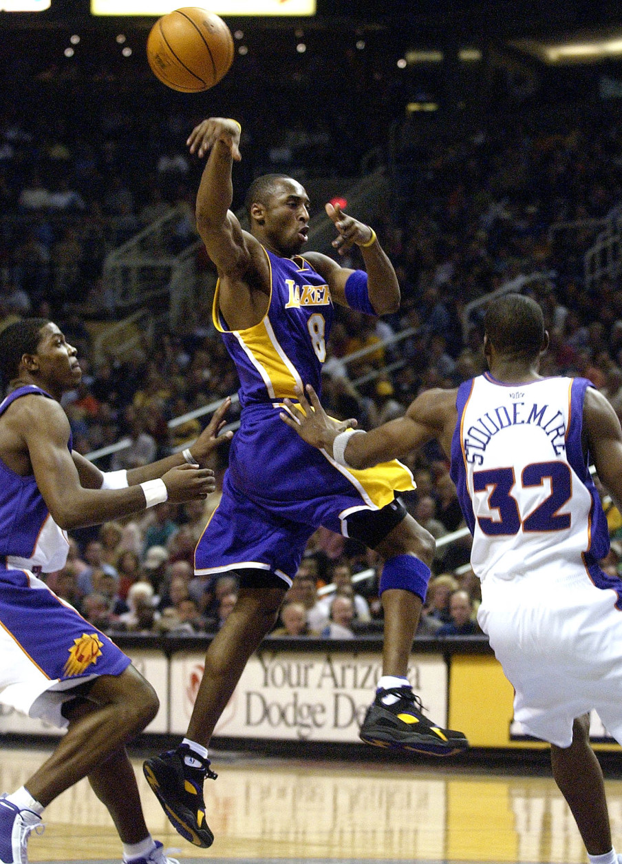 Los Angeles Lakers' Kobe Bryant (8) dishes off against the Phoenix Suns' Amare Stoudemire (32) and Joe Johnson during the first quarter Saturday, Nov. 1, 2003 at America West Arena in Phoenix. (AP Photo/Matt York)