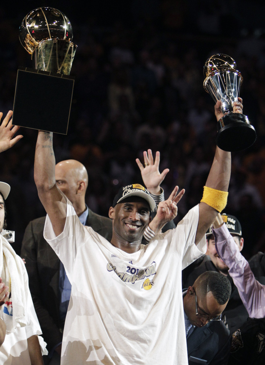 Los Angeles Lakers guard Kobe Bryant holds the Larry O'Brien trophy, left, and the most valuable player trophy after winning the NBA basketball championships against the Boston Celtics Thursday, June 17, 2010, in Los Angeles. The Lakers won 83-79. (AP Photo/Jae C. Hong)
