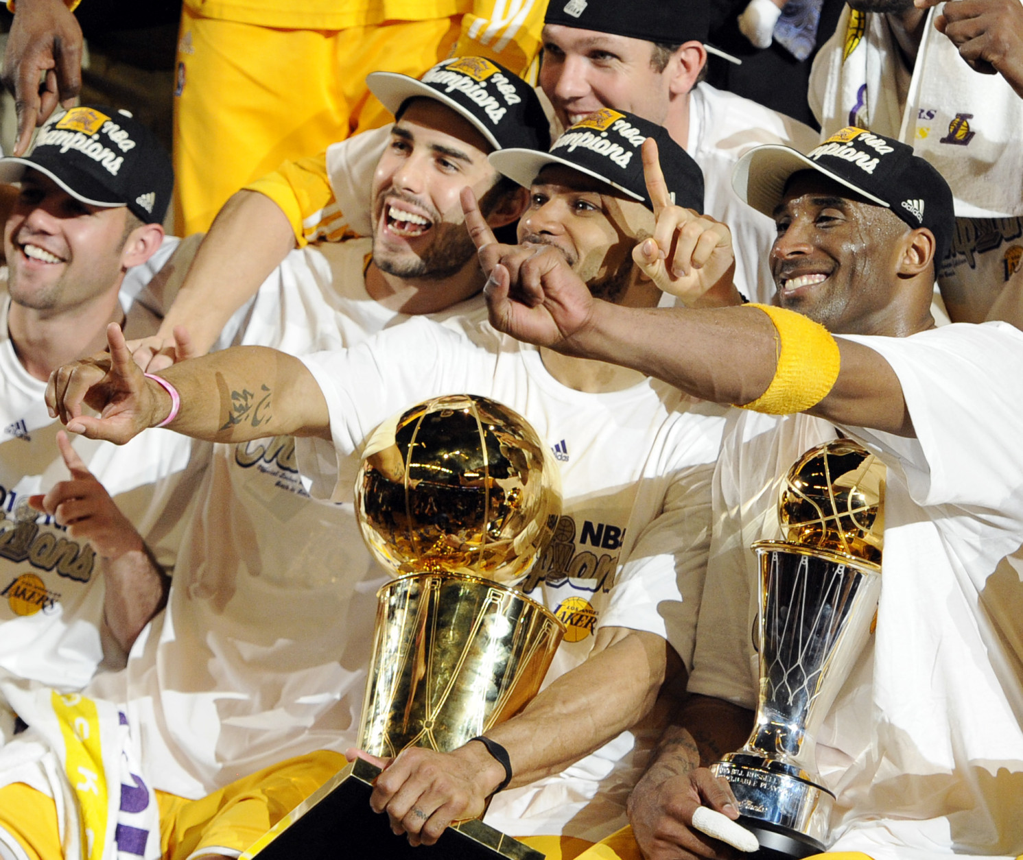 Los Angeles Lakers guard Derek Fisher, center, holds the Larry O'Brien Trophy as Kobe Bryant, right, holds the MVP trophy as they celebrate after beating the Boston Celtics, 83-79, in Game 7 of the NBA basketball finals Thursday, June 17, 2010, in Los Angeles. At second left is Lakers' Sasha Vujacic.  (AP Photo/Mark J. Terrill)