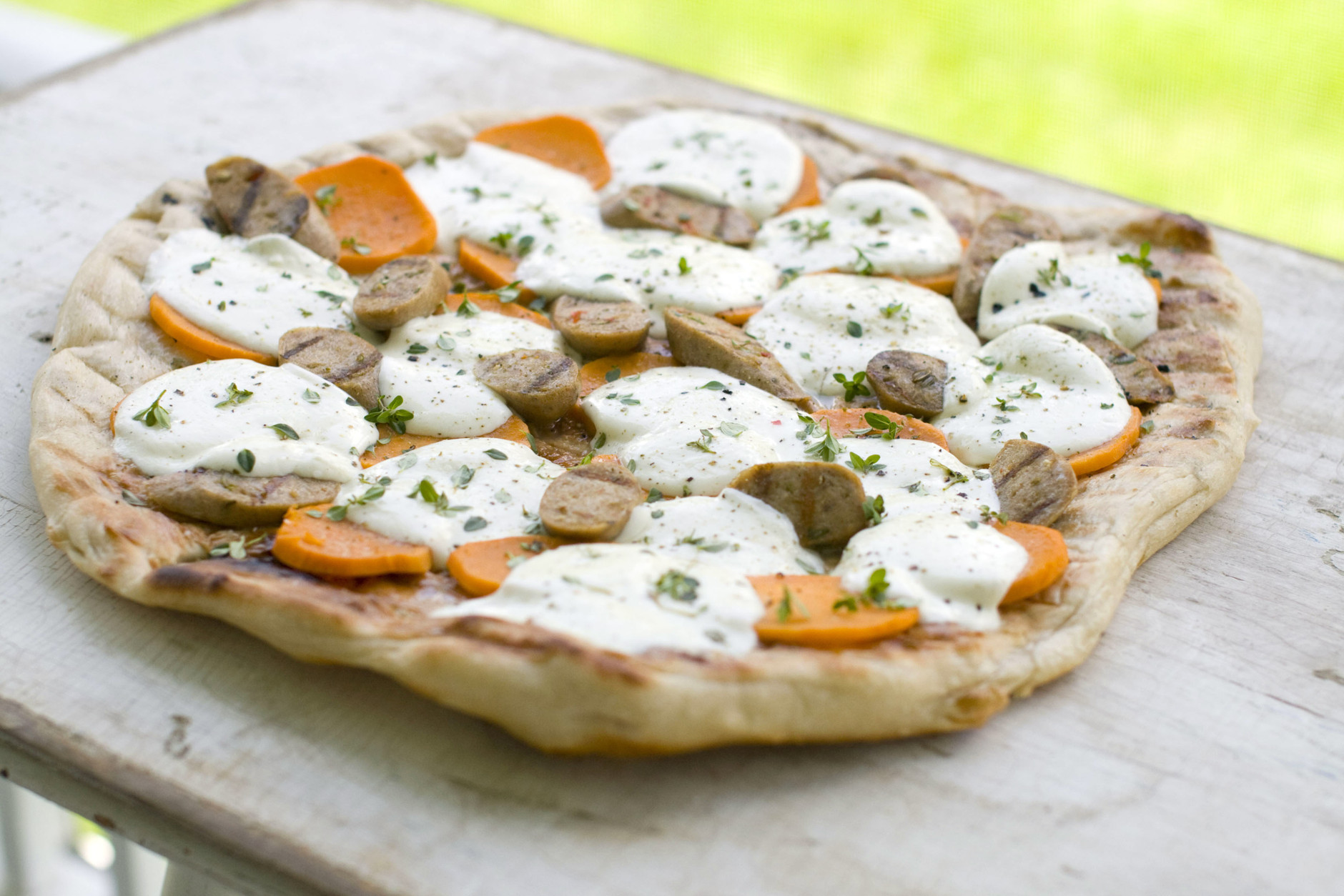 This May 23, 2011 photo shows grilled sweet potato and sausage pizza in Concord, N.H. Grilling infuses pizza with a wonderful smoky flavor and a crisp, chewy crust.     (AP Photo/Matthew Mead)