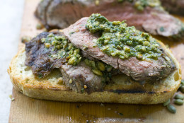 In this June 2011 image taken in Concord, N.H., a chimichurri-like sauce with pepitas tops grilled flank steaks on toasted sourdough bread. (AP Photo/Matthew Mead)
