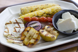 This image taken on Sept. 8, 2011 shows a recipe using the Greek grilling cheese, Halloumi, in a salad combined with grilled corn, apples and onions served on a platter, in Concord, N.H. (AP Photo/Matthew Mead)