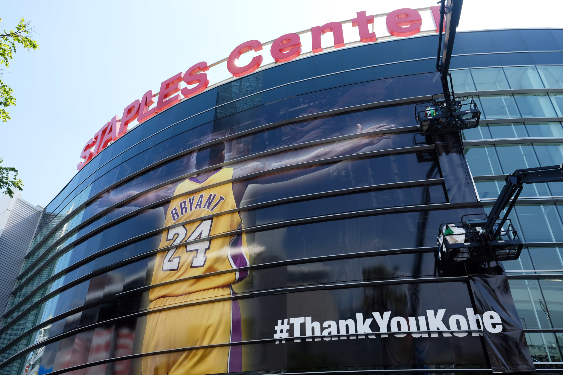 Workers wrap Staples Center in a giant banner congratulating Kobe Bryant before his last NBA basketball game, a contest against the Utah Jazz, in downtown Los Angeles Wednesday, April 13, 2016. Many of Bryant's fans - even some of the adults - have never known Los Angeles without him. I's a feeling they're about to have to get used to as fans celebrate his final night as a Laker. (AP Photo/Richard Vogel)